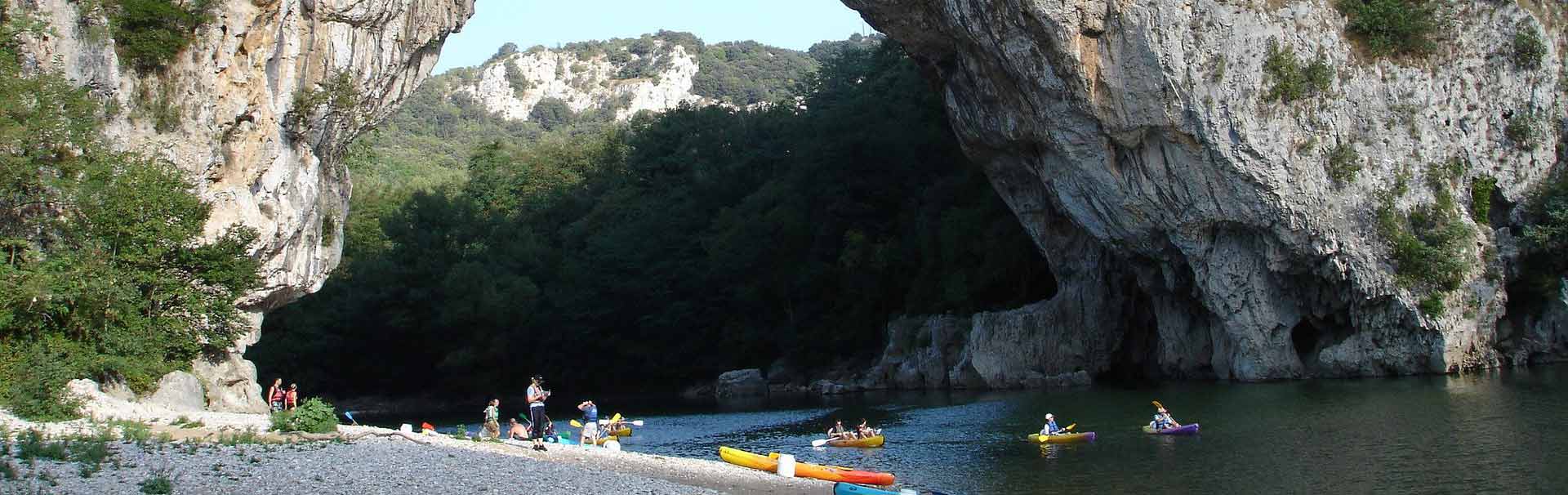 Groupe en canoe faisant une pause sur une petite plage dans un paysage Ardéchois